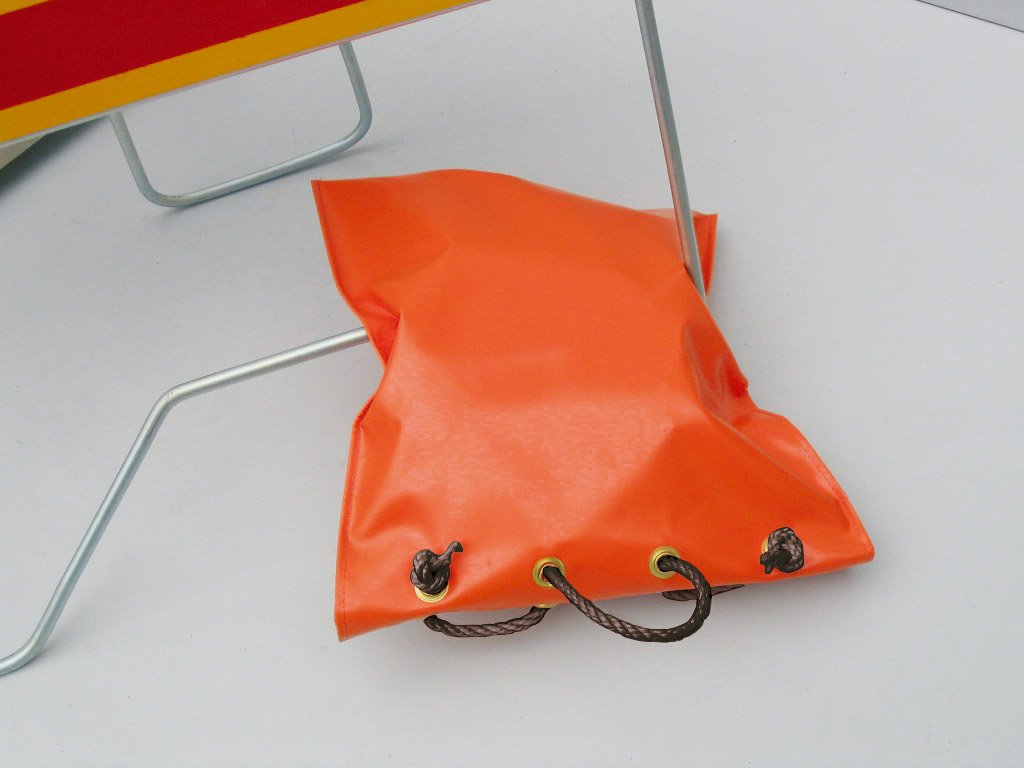 PVC sandbag coloured in orange and designed with black strings to keep it tight to use