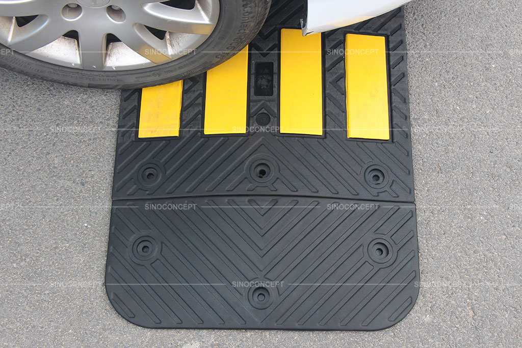 Black speed hump made of vulcanized rubber and pasted with yellow reflective tapes for traffic safety