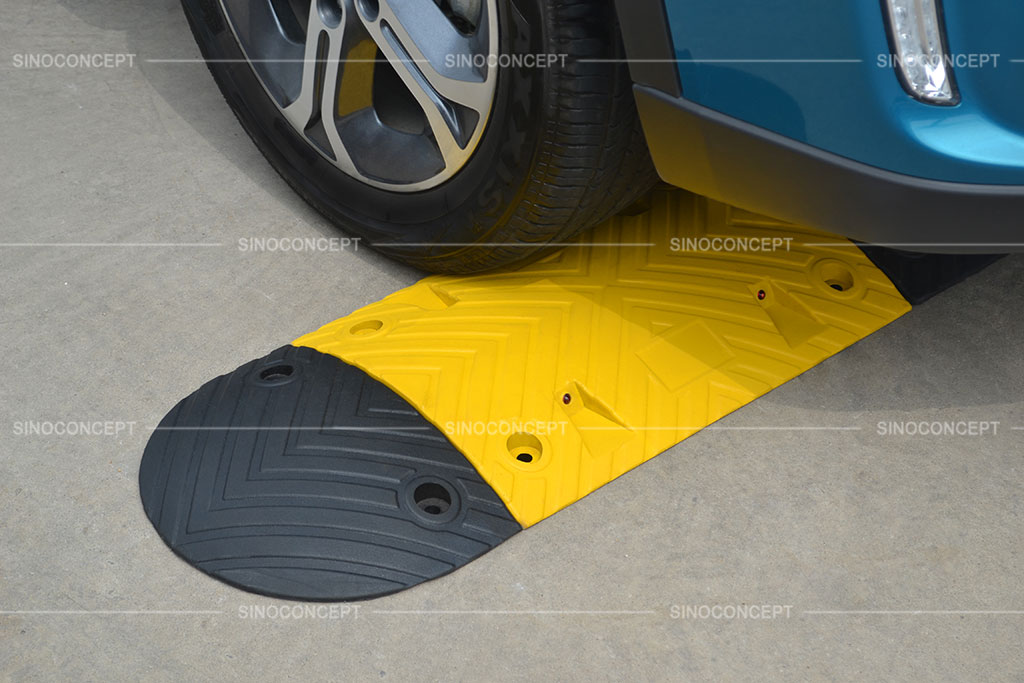 Black and yellow speed ramp made of rubber with anti-slip surface design and road studs embedded