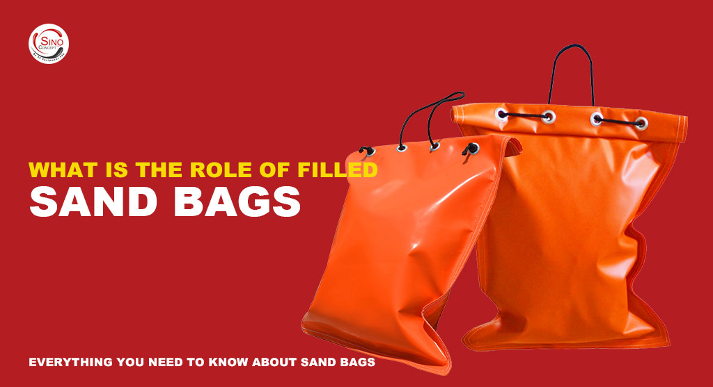 Two orange sand bags made of pvc material and pre-filled with sand for traffic safety purpose