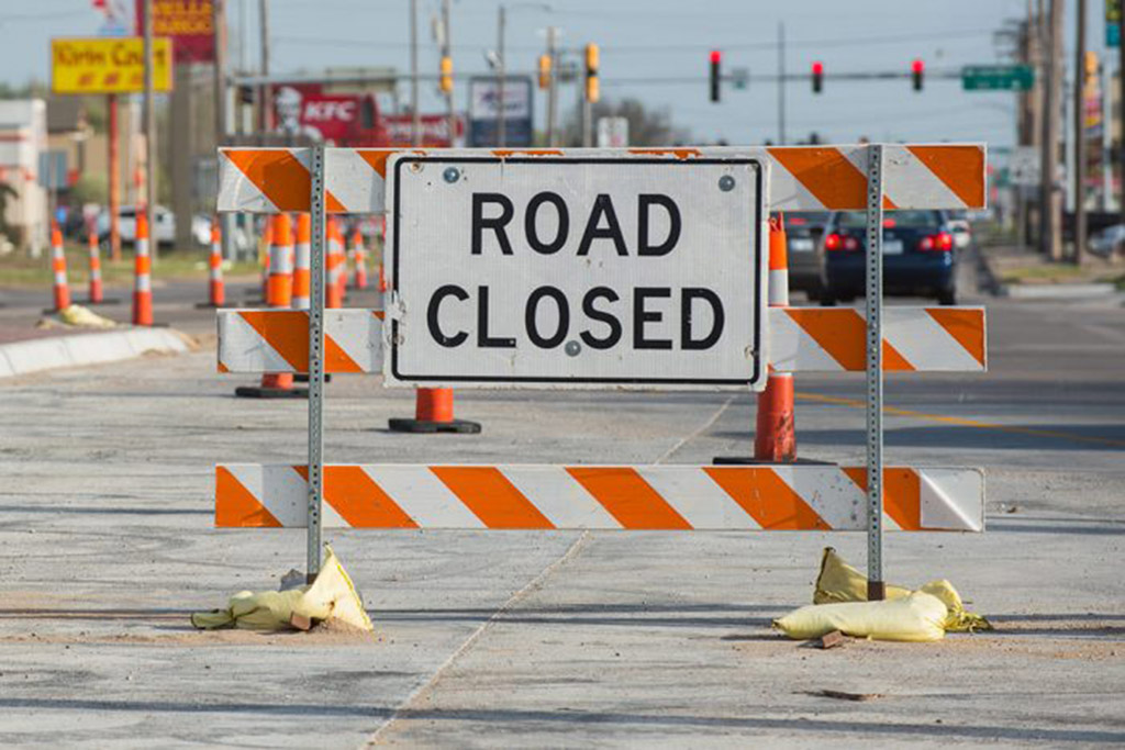 Filled sandbags are used to hold down construction warning signs on the road construction sites