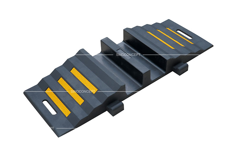 A black rubber hose protector ramp with yellow reflective films to protect hoses or cables.
