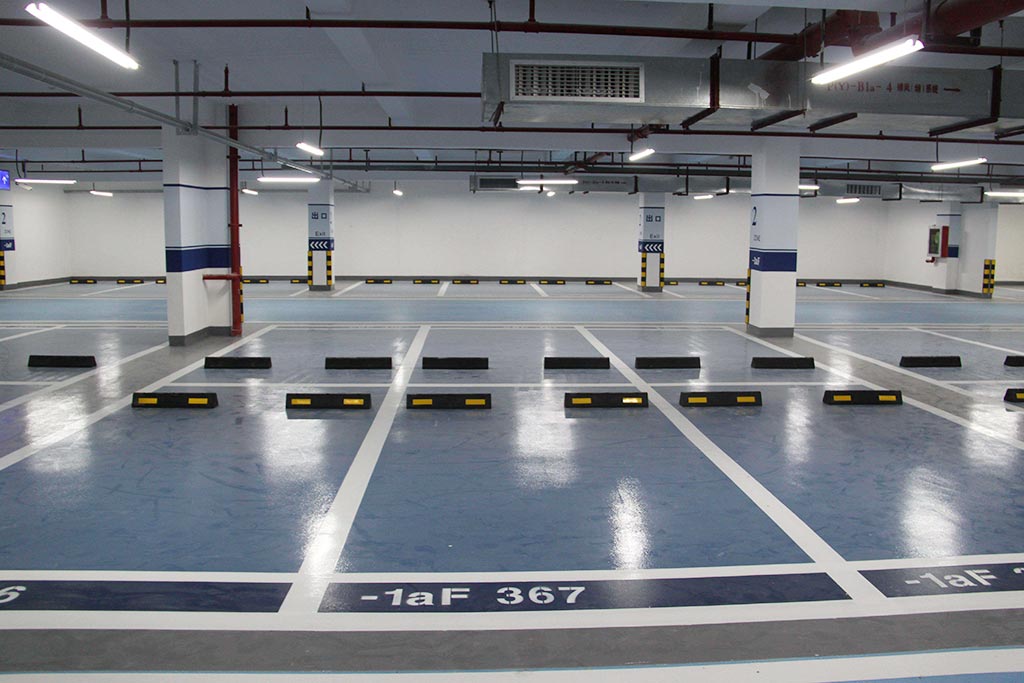 Many rubber parking wheel stops are set in an indoor parking lot for better parking safety