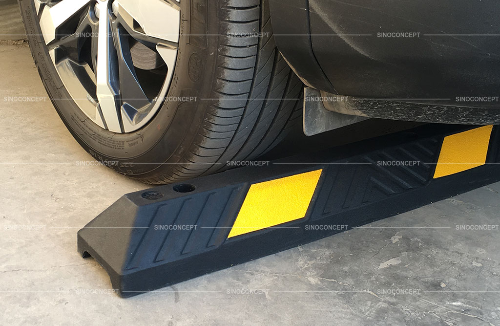 A black rubber parking stop pasted with yellow reflective films used for parking safety