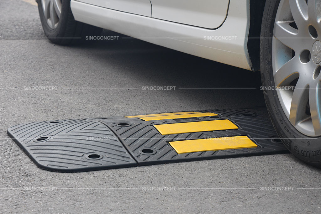 Rubber speed hump designed with anti-slip surface and pasted with yellow reflective tapes for traffic calming purpose