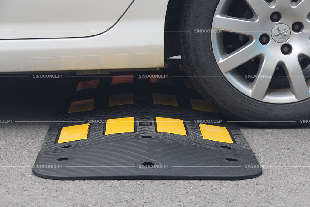 A black traffic calming hump designed with anti-slip surface and pasted with yellow reflective films