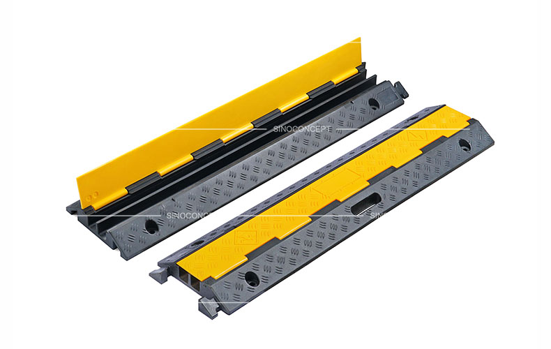 Two channels cable ramps made of rubber also called floor cable covers designed with anti-slip surface and yellow plastic covers.