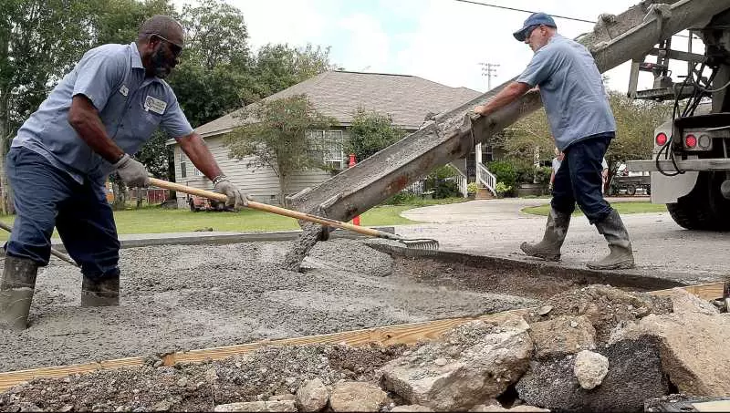 Two men are working with the concrete.