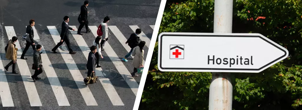 Pedestrians are crossing the crosswalks, and a hospital traffic sign.