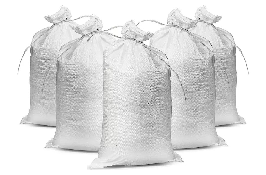 Five white filled sandbags made of woven polypropylene.