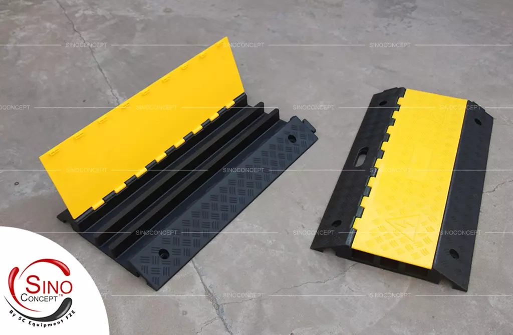 Two black rubber cable protector ramps with yellow plastic lids to protect wires.
