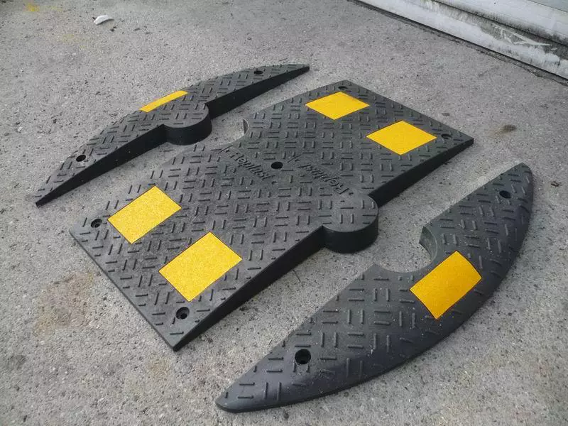 Black and yellow recycled plastic speed humps with yellow refllective stripes.