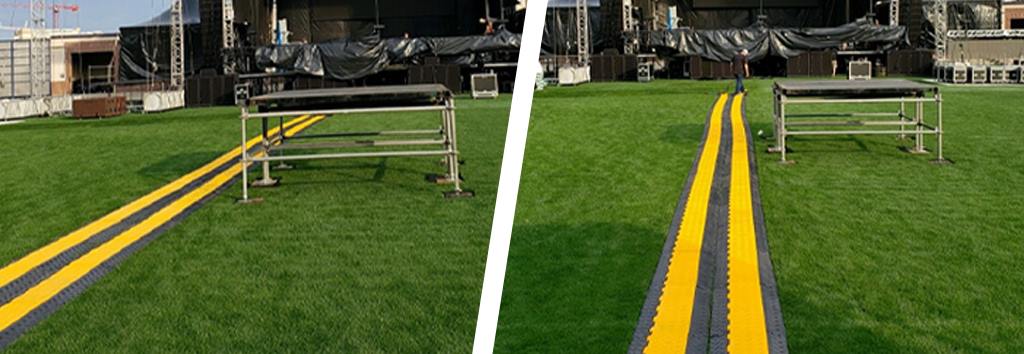 Black and yellow cable ramps on the green lawn to protect cables and reduce trip hazards.