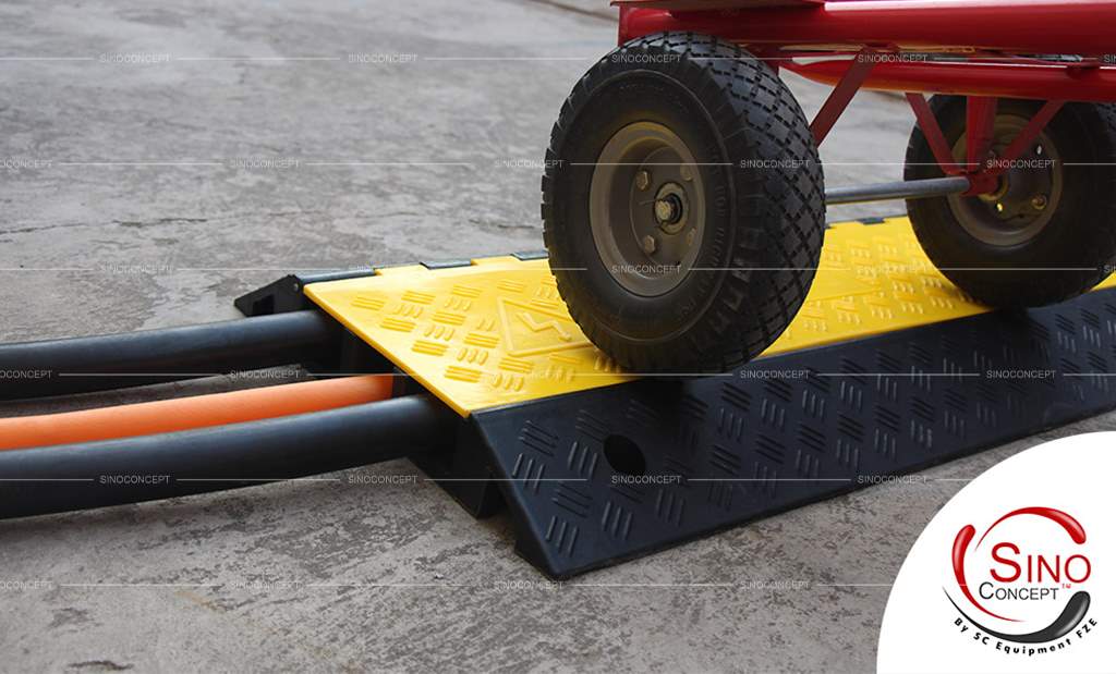 An outdoor rubber cable ramp on the ground to protect the cables from vehicles and pedestrians.