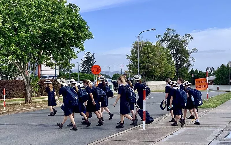 A group of school students are crossing the road.