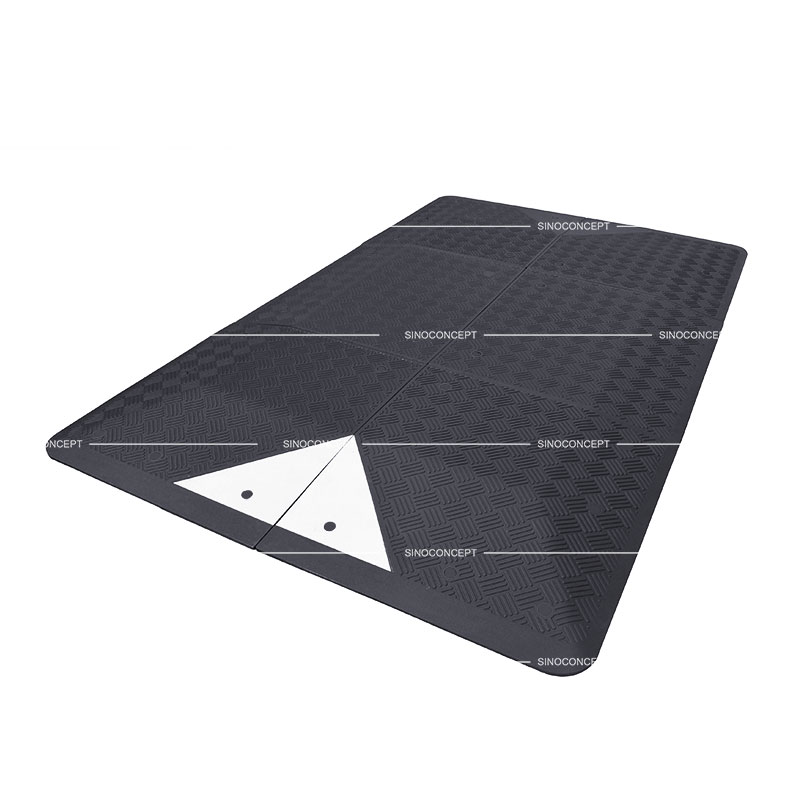 A black rubber UK style speed cushion of six parts for traffic-calming purposes.