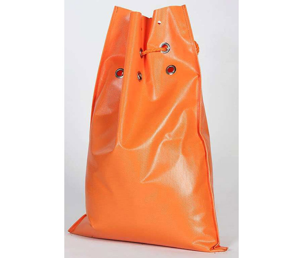 An orange sand bag is filled with sand, used for traffic management