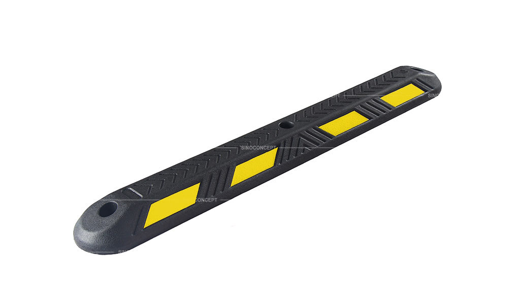 A close-up image of a black rubber lane divider with yellow reflector films