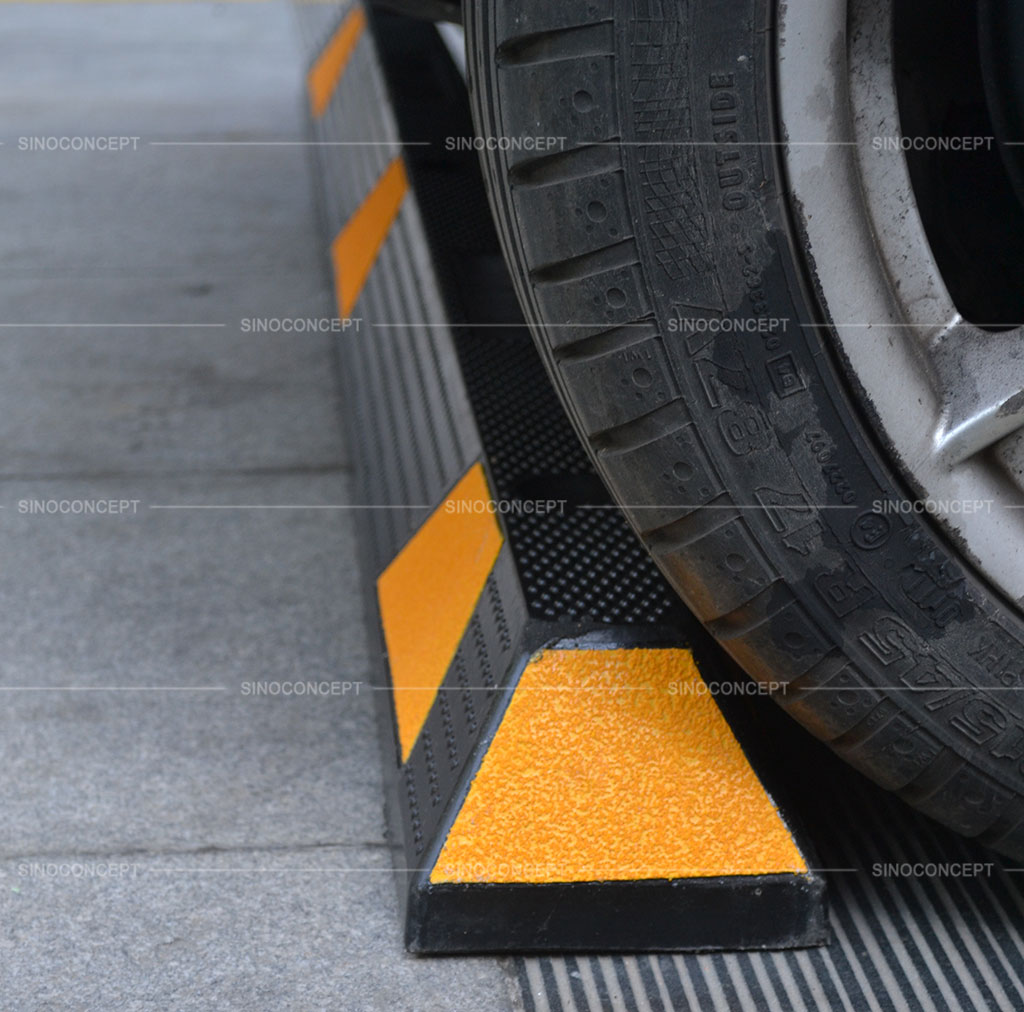A black wheel stop pasted with yellow reflective films to stop cars' movement