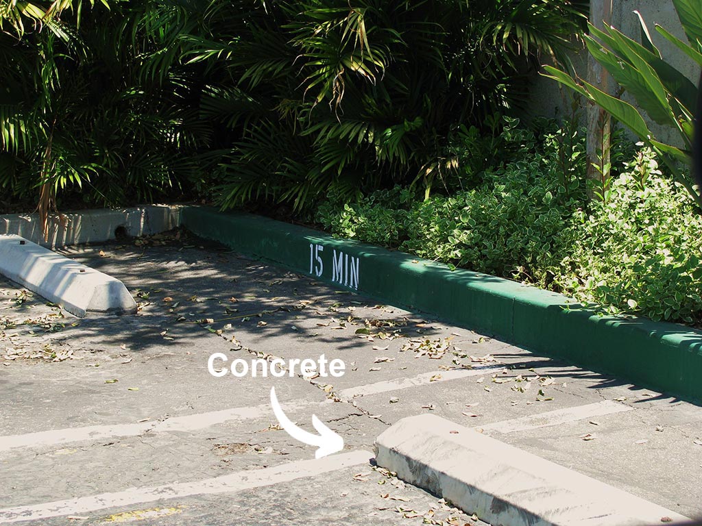 Concrete wheel stops installed in an outside parking space to stop wheels from further movement