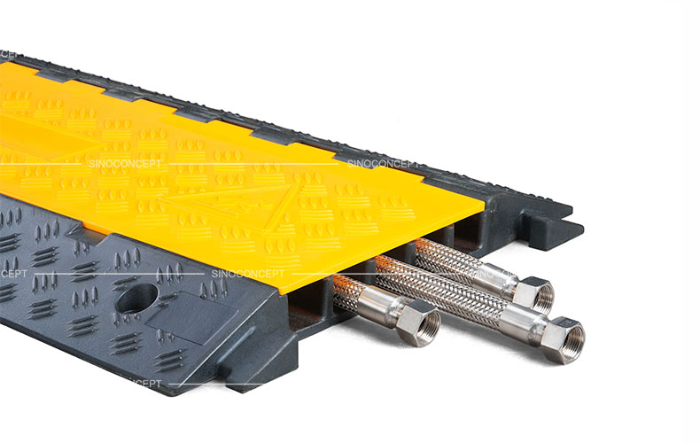 A 5-channel cable ramp made of rubber with anti-slip surface and yellow plastic covers to protect hoses or cables.