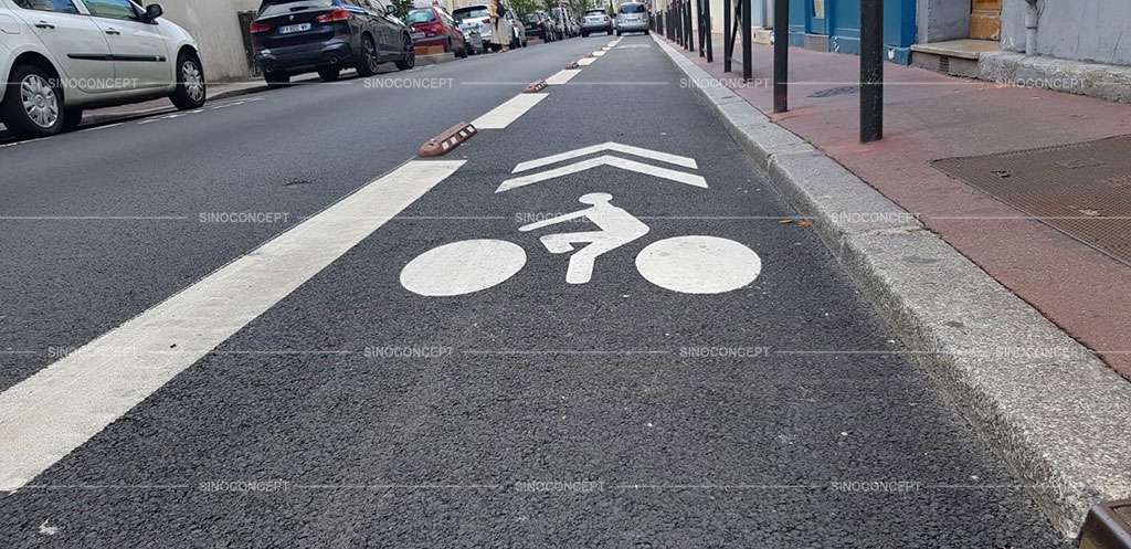 Red and white lane separators installed on the street together with some white road markings to separate different lanes