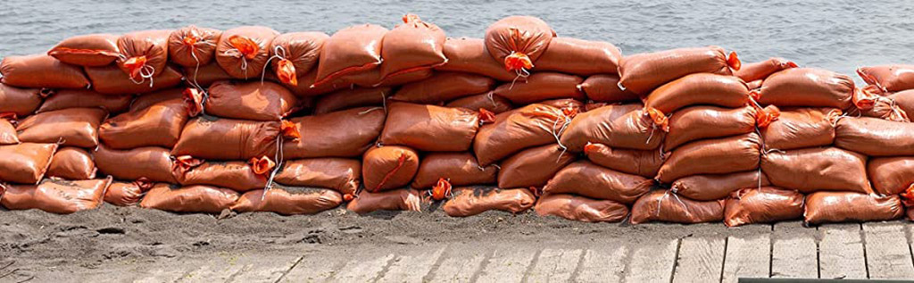 A lot of orange sandbags are put together to stop the flooding