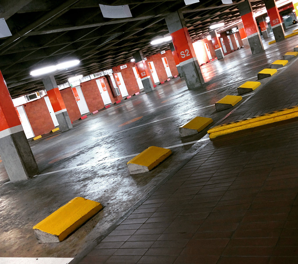 Parking bumpers coloured in yellow in an indoor parking lot for parking management