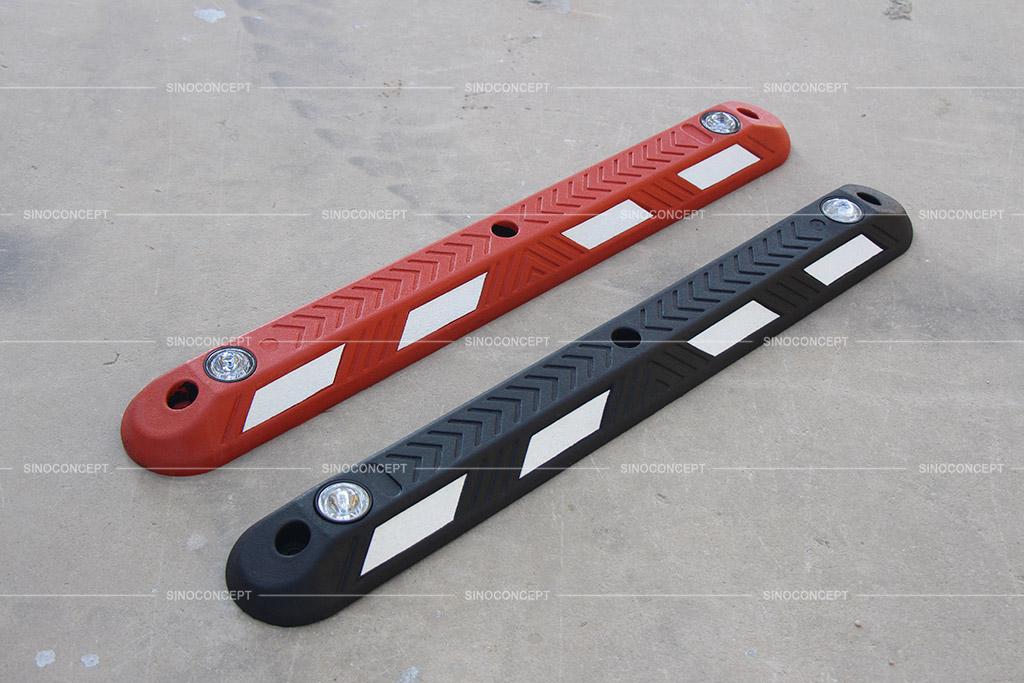 Red and black cycle lane separators pasted with white reflective films and emebedded with road studs