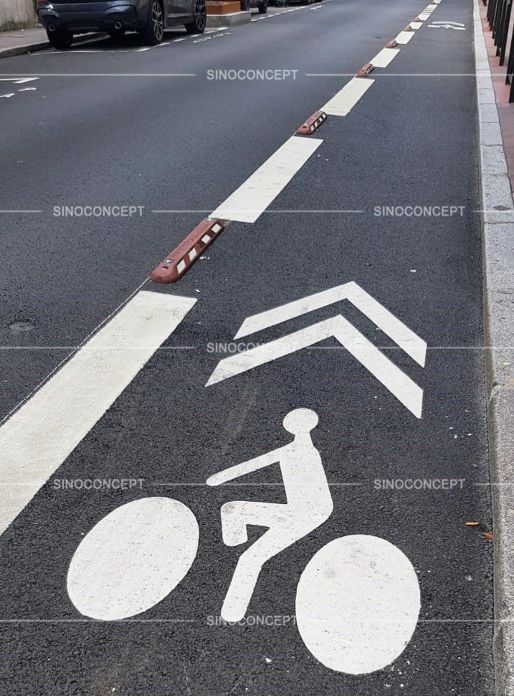 Red cycle lane dividers with road studs and white reflective films installed on the road to ensure traffic safety