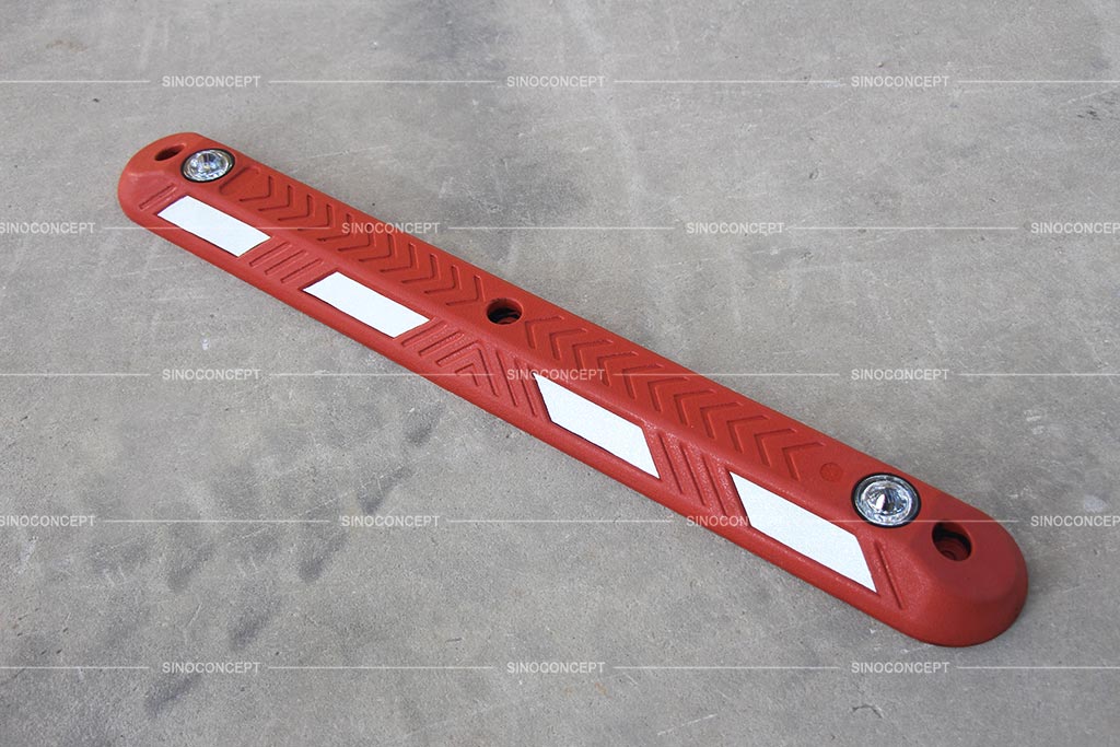 Red rubber lane dividers with road studs embedded and white reflective films pasted