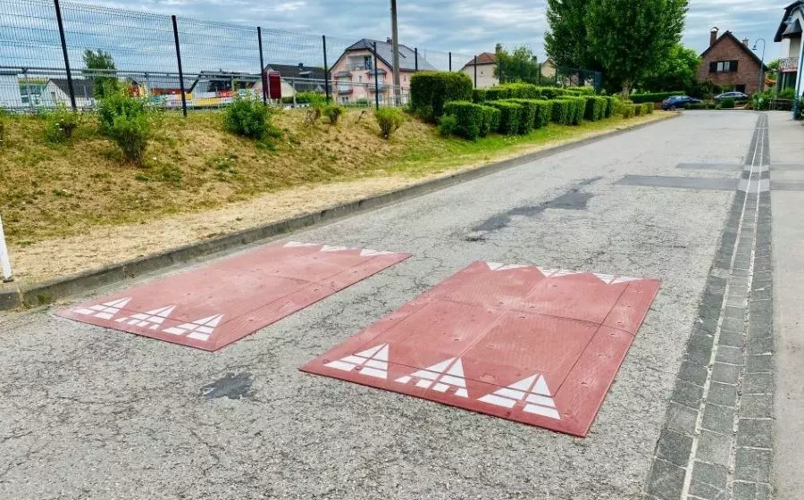 Two red rubber speed cushions are installed in the middle of the road to reduce the speed of vehicles.