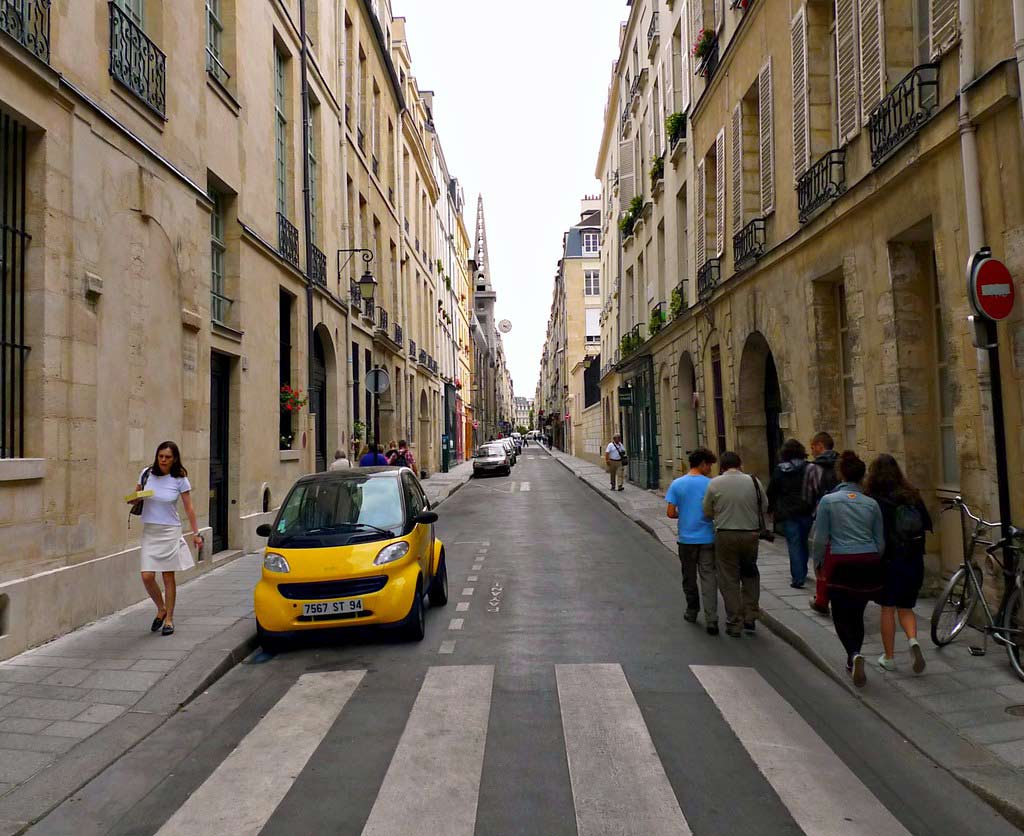 A road with zebra line markings and pedestrians
