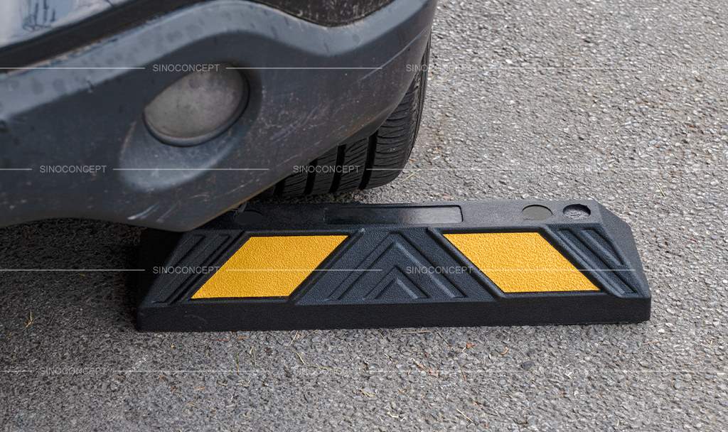 Rubber wheel stop, also called parking stopper, made of black recycled rubber with yellow reflective films used as car park safety equipment.