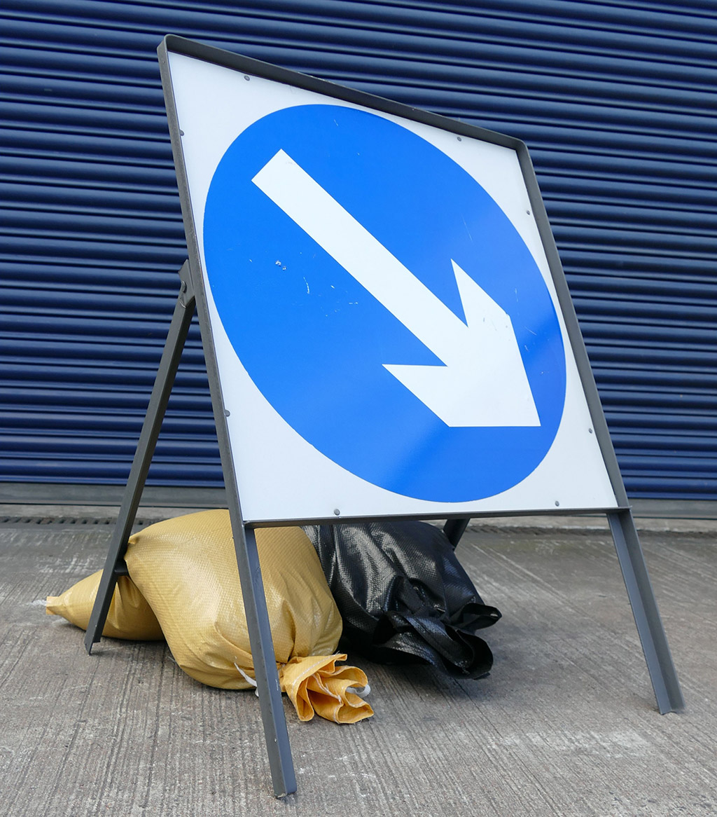 Traffic sandbags are used to hold down traffic signs along the road