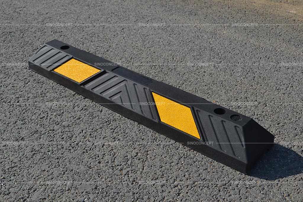 A black wheel stop made of vulcanized rubber and designed with arrow strips surface