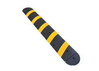 Rubber speed bump of 1830 type made of yellow and black vulcanized rubber used in a parking lot for traffic calming purpose