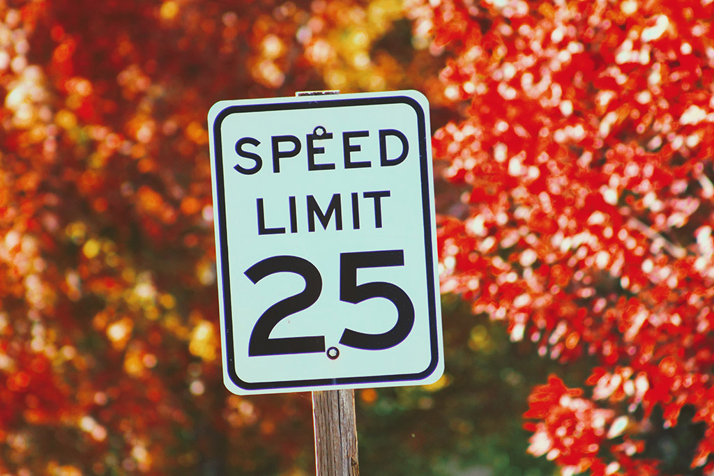 Traffic speed limit sign fixed along the road to remind drivers not to drive above the speed shown on the sign