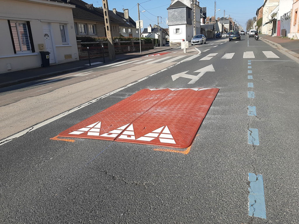 A red speed cushion is just installed along the road to better calm traffic