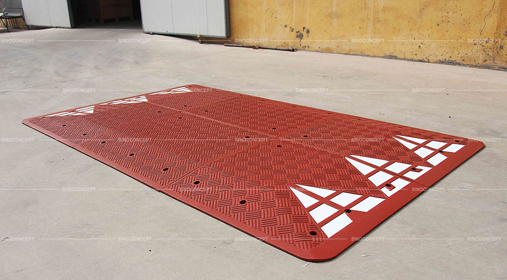 A red European speed cushion made of vulcanized rubber with white reflective films for traffic calming