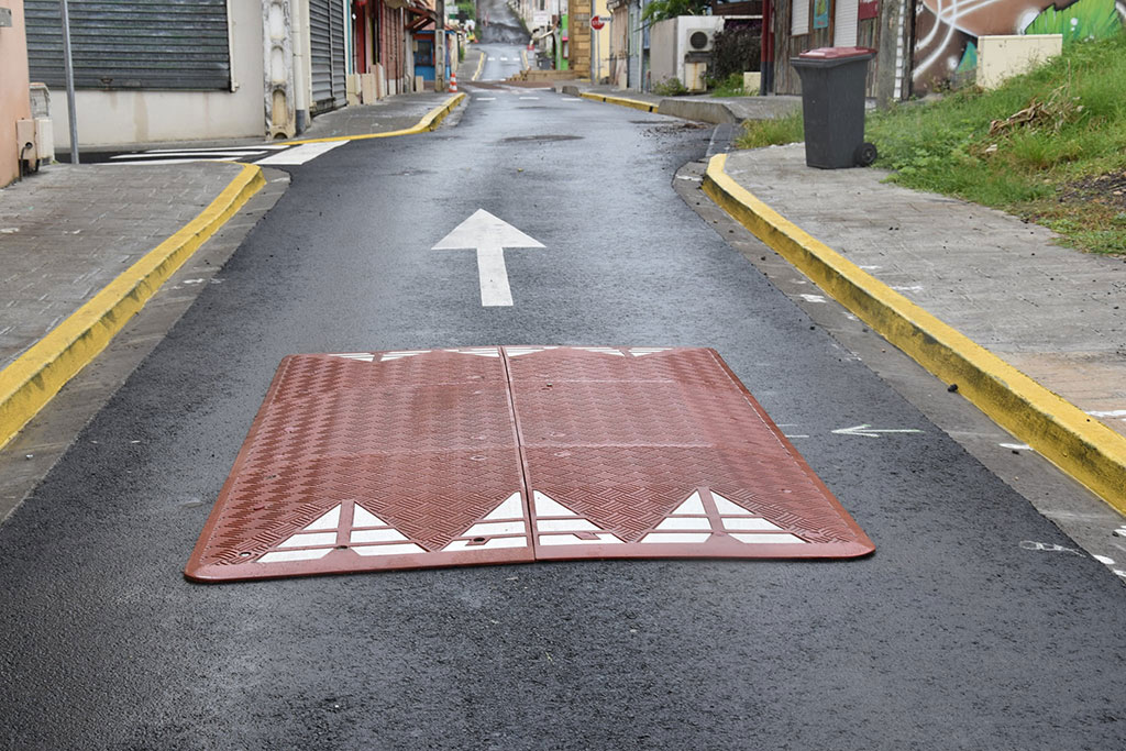 Red speed cushion also called speed table made of vulcanized rubber with white arrow signs