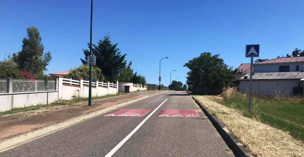 Two red speed cushions also called speed pillows are placed on the village road to ensure safety