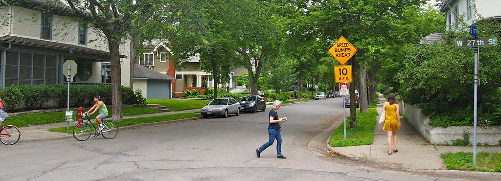 A yellow signpost to remind people of speed bumps ahead