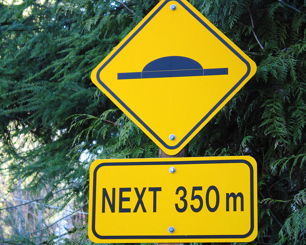 Yellow traffic signs indicate there is a speed bump or speed cushion after 350m