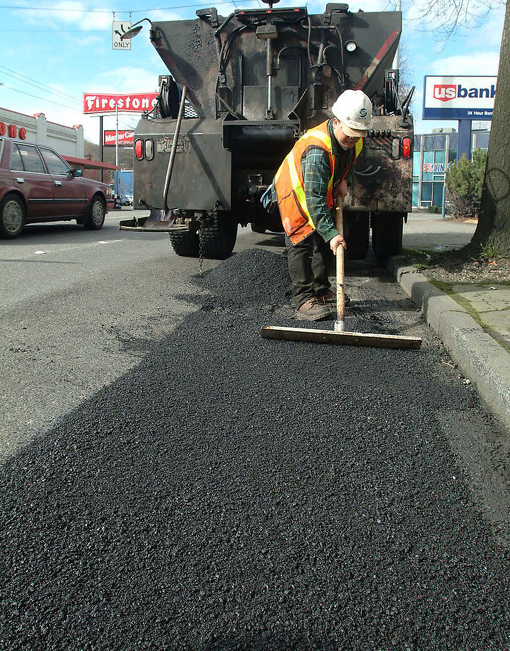 A worker is making an asphalt traffic calming device