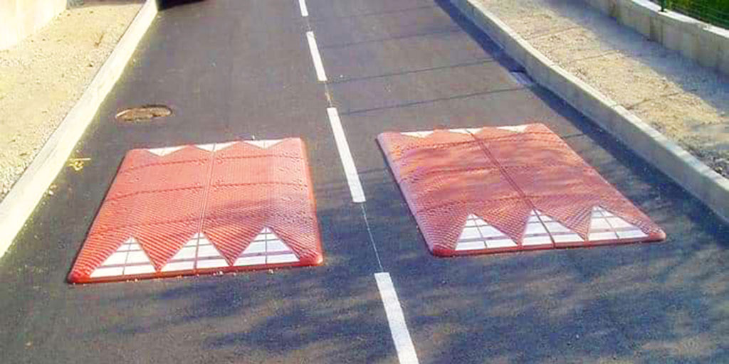 Two red speed cushions also called speed tables pasted with white reflective films for traffic calming