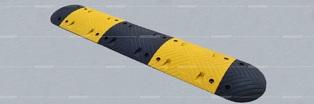 Rubber speed breaker also called speed bump coloured in black and yellow with embedded cat-eye road studs