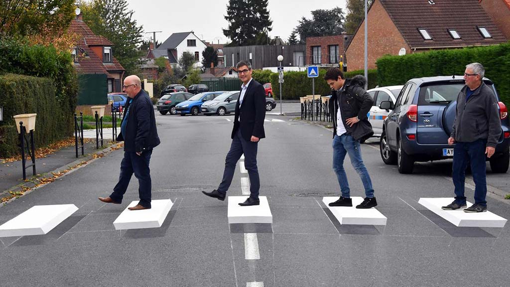 People are standing on the white optical illusion speed bump