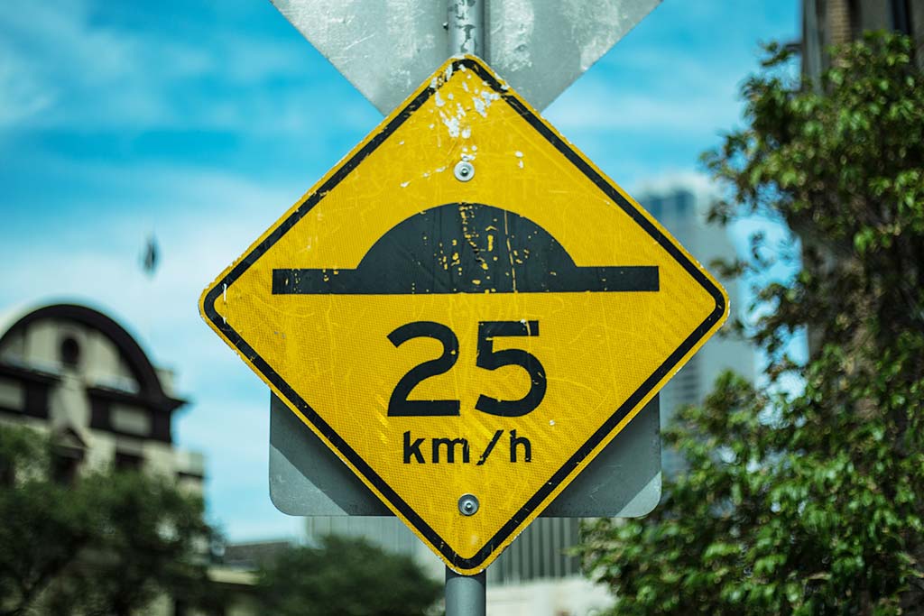 A yellow sign post to indicate the exist of speed bump