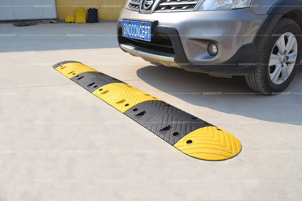 Recycled rubber speed bump coloured in black and yellow, designed with arrow anti-slip surface for car park management